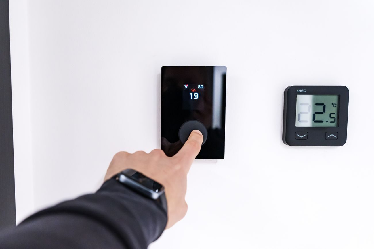 A hand operating a wall mounted home control panel