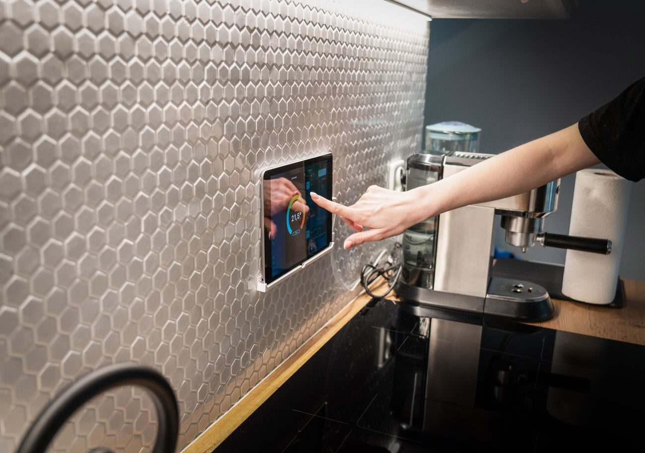 A wall mounted smart control panel in a modern interior